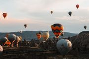 A photograph of hot air balloons over rock valleys.