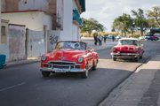 A photograph of a red convertible on a Havana street.
