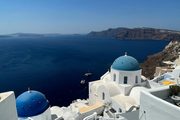 A photograph of blue-domed churches above the sea.